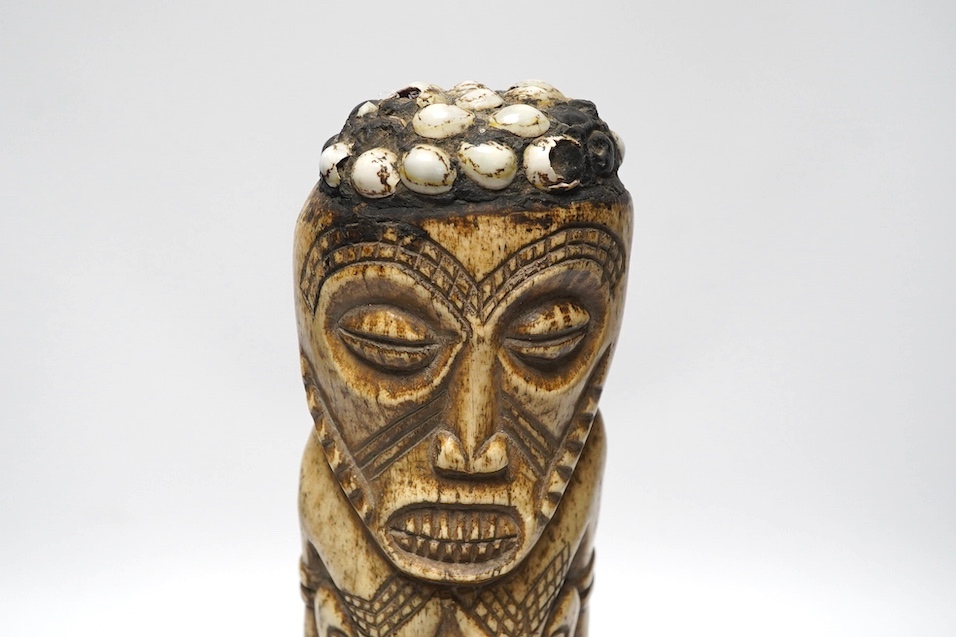 A West African carved animal bone fertility figure, 34cm. Condition - fair